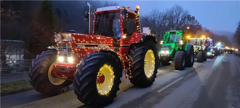 Линия тракторов с волшебными огнями, красный трактор впереди