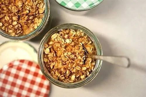 Хрустящие овсяные хлопья в стеклянной миске с ложкой и красными и зелеными крышками