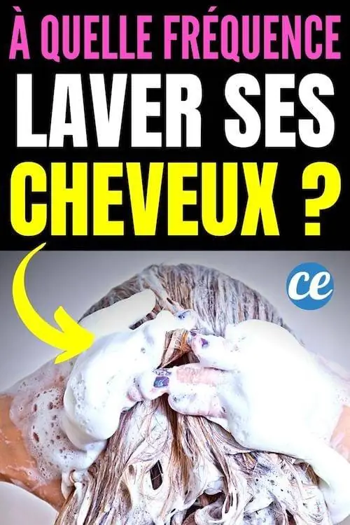 Улыбающаяся женщина моет волосы большим количеством шампуня