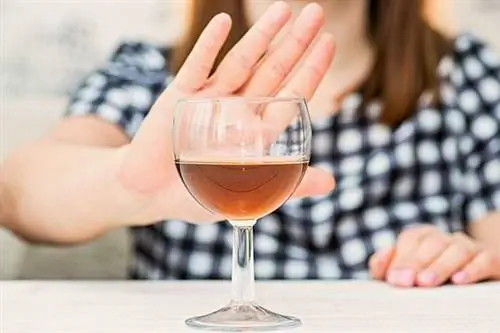 Женщина отталкивает стакан алкоголя