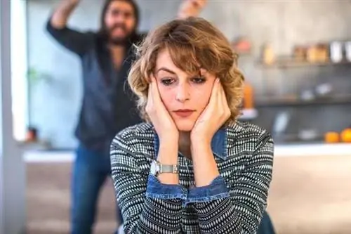 Женщина выглядит раздраженной размытым фоном и мужчиной на заднем плане