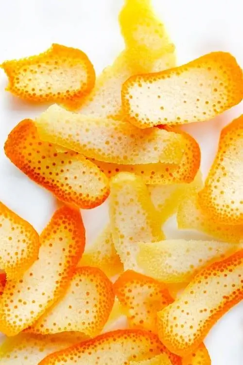 Кусочки апельсиновой корки на белом фоне. Кусочки апельсиновой корки на белом фоне.