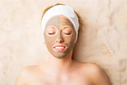 Женщина, намазавшая лицо глиной, чтобы насладиться ее преимуществами