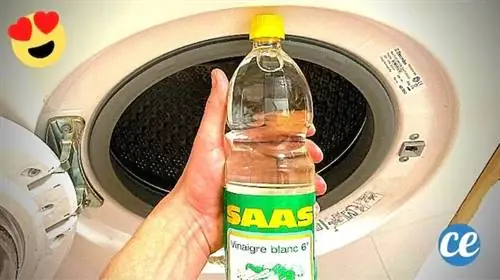 Бутылка белого уксуса перед барабаном стиральной машины