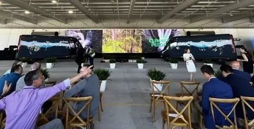 Два изготовленных на заказ электромобиля Amazon Rivian демонстрируются перед аудиторией на объекте Amazon в Чикаго.