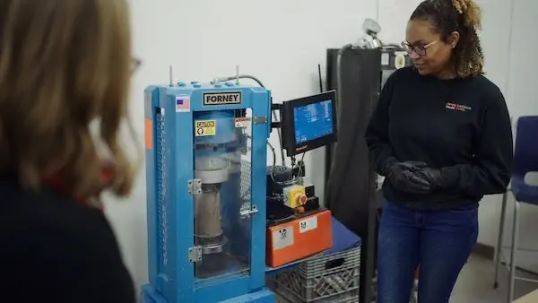 Две женщины смотрят на машину в лаборатории.