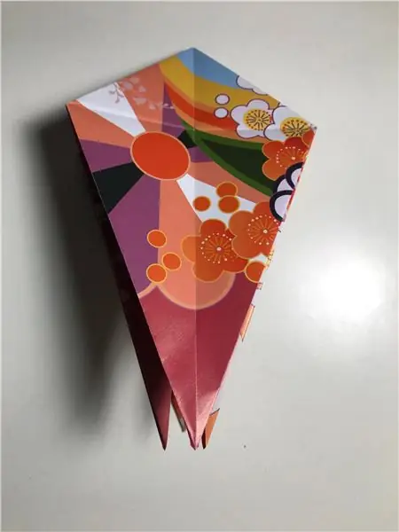 Сложите лоскут вверх, чтобы получилось ухо. Убедитесь, что он совпадает с линией пролива, как показано, затем сгладьте