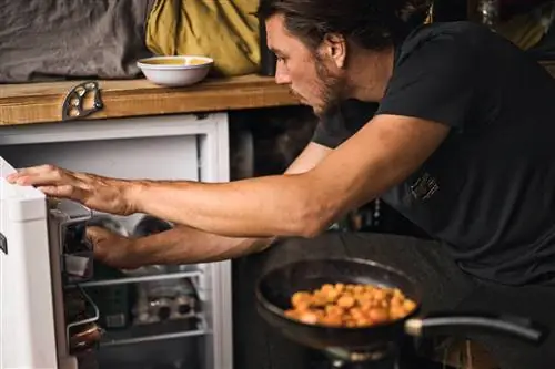 Мужчина готовит в фургоне