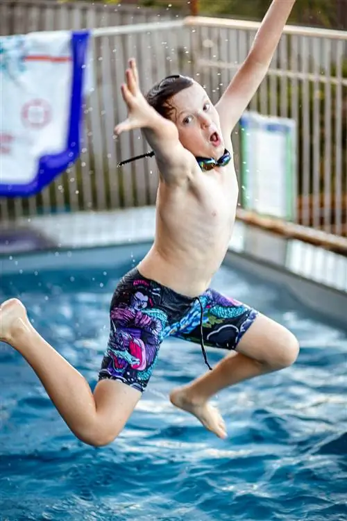 Семейное фото: мальчик прыгает в бассейн
