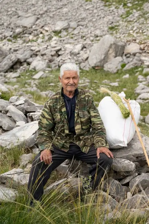 Христос, 80-летний местный житель, отдыхает после утреннего сбора трав для греческого «горного чая» на