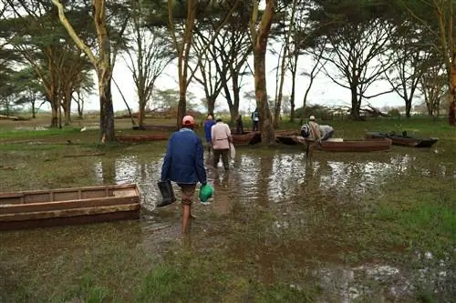 Рыбаки пробираются по заболоченной береговой линии к своим лодкам.