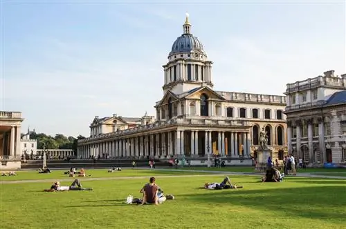 Лондонцы отдыхают на солнечных лужайках возле Старого Королевского военно-морского колледжа. Комплекс в стиле барокко 18 века,