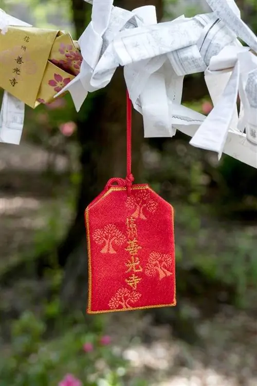 Омамори, шелковый мешочек для молитв, висит возле храма в Нагоно, Япония.