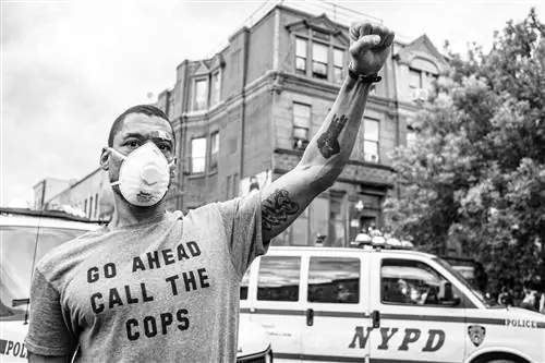 Кайл Эррисон поднимает кулак в знак солидарности с участниками марша, которые скандировали «Справедливость для Джорджа Флойда». Эррисон