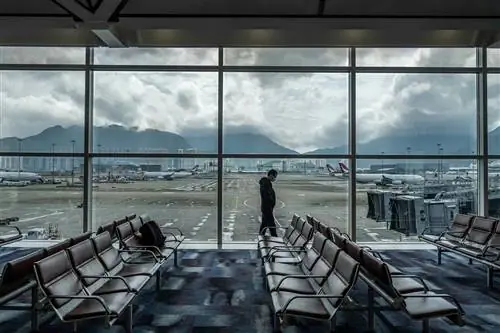 Мужчина проходит мимо окон в международном аэропорту Гонконга 14 февраля.