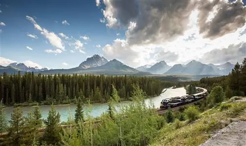 Поезд пересекает нетронутый ландшафт Канады.
