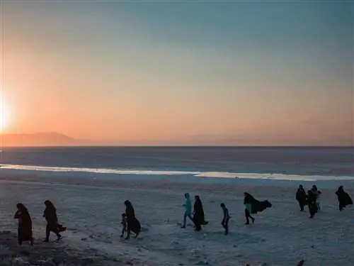 Семья гуляет на закате у озера Урмия.